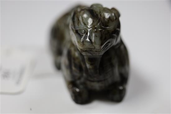 A Chinese pale grey and black jade recumbent figure of a lion-dog, length 8.3cm